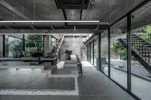 Industrial kitchen with a large dining table, appliances, and a concrete floor, creating a clean and well-organized atmosphere
