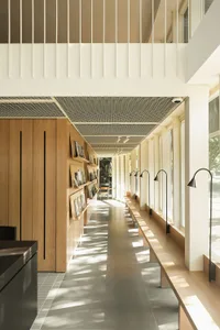 A modern hallway lined with bookshelves and books, well-lit by natural or artificial light
