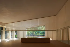 Open modern living area with natural light, two benches, and a dining table