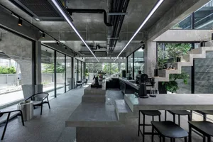 Open modern kitchen and dining space with a large countertop island, potted plants, and various appliances