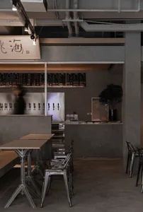 A modern Asian restaurant with a bar area and dining tables, featuring bottles and an inviting atmosphere