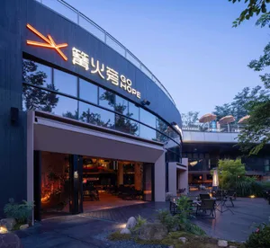 Modern Asian restaurant with a large dining area, wood and metal elements, umbrellas, and a comfortable atmosphere