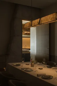 A white table set with wine glasses, plates, and tableware, creating an inviting atmosphere for a sophisticated dining experience