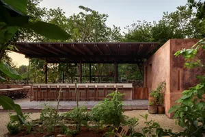 A relaxing outdoor patio with a dining table surrounded by chairs and potted plants, suitable for social gatherings or events