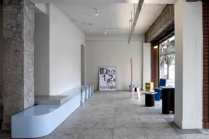 Empty industrial space with a concrete floor, featuring benches, chairs, and dining tables in a minimalist and clean atmosphere