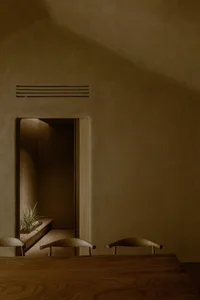 Empty room with stone walls, a doorway, and three chairs creating a welcoming atmosphere