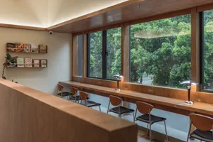 Cozy restaurant interior with wooden floors and walls, large windows, and natural light