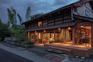 Asian-style house with a wooden exterior, a large living area, a dining table, and natural light