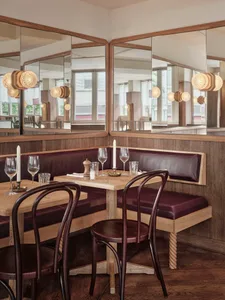 A cozy cafe with wooden tables and chairs, wine glasses, and candles creating a warm atmosphere