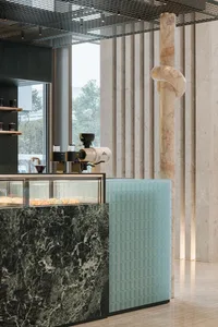 A well-organized coffee shop with a marble countertop, display case, and modern appliances