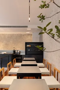 Inviting restaurant interior with wooden tables, chairs, and cups, set up for customers to enjoy their meals