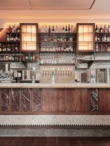 A well-stocked bar with a wooden counter and numerous bottles displayed, creating an inviting atmosphere for patrons
