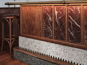 Kitchen with a wooden countertop, marble backsplash, and a chair for seating, set against a neutral background