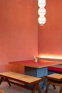 A dining table surrounded by chairs in a cozy restaurant with a wooden table and inviting atmosphere