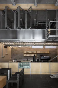 A modern kitchen with wooden walls and floors, featuring a refrigerator, microwave, and sink, with a well-planned layout for cooking and food preparation