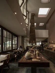 溫馨現代餐飲空間，木質特色牆、多張餐桌椅及柔和燈光