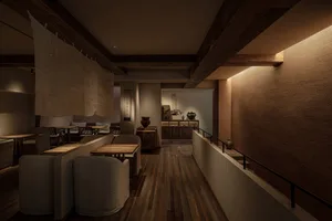 Warm and inviting restaurant interior with wooden floors and walls, featuring chairs, tables, a couch, and decorative vases
