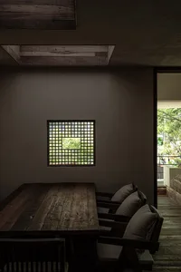一個舒適的餐廳空間，桌旁環繞三張帶有軟墊的椅子，營造溫暖親切的氛圍