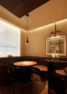 Warm and inviting dining space with brown leather chairs and tables, dimly lit for a cozy ambiance