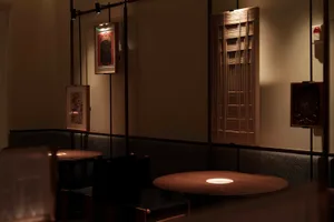 Warm and inviting dining space with wooden tables, chairs, and artworks, designed for socializing and enjoying meals together