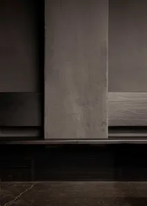 Exposed concrete wall with a weathered and worn finish, possibly from a building interior