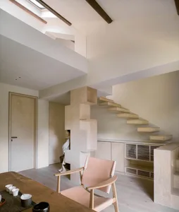 Warm and inviting open concept living area with a large wooden table and two chairs, surrounded by ample seating options