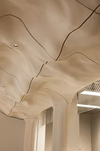 A warm and inviting interior space with a large wooden ceiling featuring a unique and intricate pattern
