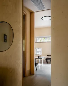 Cozy home hallway with a doorway, two chairs, a dining table, and a vase, creating a warm and inviting atmosphere
