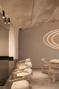 A modern restaurant dining area with three chairs and two tables, featuring a comfortable and inviting atmosphere
