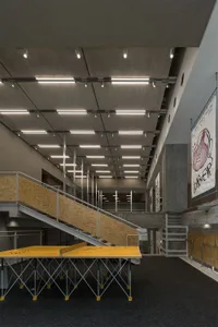 A modern interior space with two sets of wooden stairs, one on each side, in a well-lit atmosphere