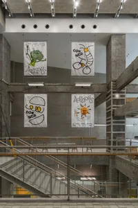 A bright and inviting open space with white posters on the walls, featuring three chairs in different locations