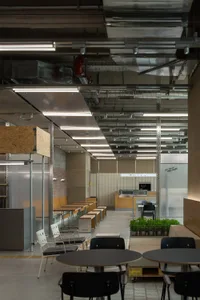 A large open cafeteria with multiple dining tables and chairs, clean and well-organized, ready for use