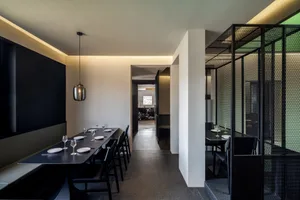 Elegant dining space with wooden furniture, multiple tables, and wine glasses, set in a comfortable and inviting atmosphere