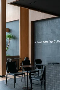 A modern dining area with black chairs and tables, well-lit with natural or artificial light