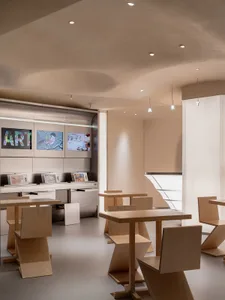 Modern restaurant interior with a large dining area, multiple tables, chairs, and TVs on the walls