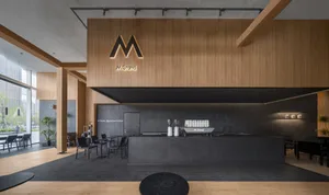 Modern cafe with black countertops, various seating options, and dining tables, creating a stylish and functional space for socializing and meals