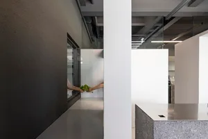 兩人在廚房中站立，配有水槽、工作檯面與休閒氛圍，周圍充滿自然光線
