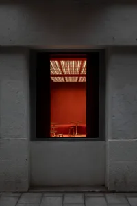 A warm and inviting dining area with orange walls, a dining table, and two chairs, creating a cozy atmosphere