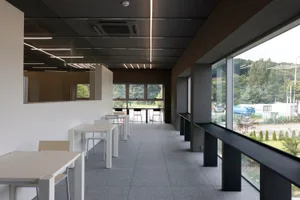 A restaurant dining area with a large white table surrounded by black chairs, creating a comfortable seating arrangement for guests