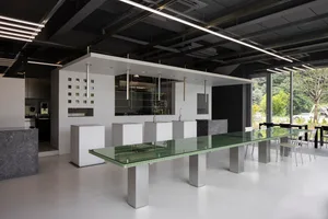Open kitchen with a glass table, white cabinets, and modern seating, featuring a clean and minimalist design