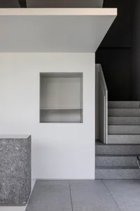 A minimalist stairwell with concrete stairs and white walls, providing a clean and bright space