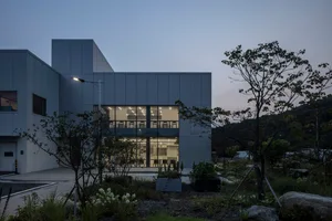 一座現代辦公大樓，擁有混凝土與玻璃立面，內部井然有序，提供員工充足空間