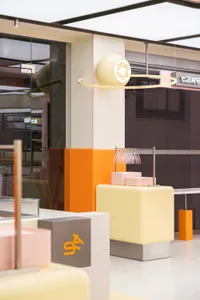A modern Japanese restaurant interior with pink walls, a large window, and a dining table with chairs, creating a comfortable and inviting atmosphere