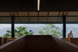 一座擁有木質外牆與大型窗戶的住宅，眺望山脈景觀，營造寧靜氛圍