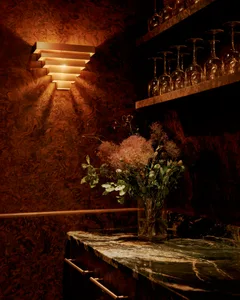 Elegant dining space with a marble countertop, brown and gold color scheme, and wine glasses