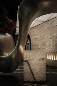 A modern interior space with a stone wall, a metal sculpture, and potted plants, conveying a contemporary and stylish atmosphere