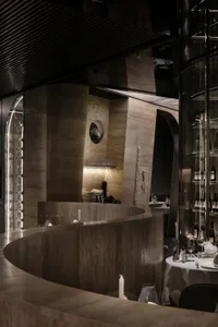 Sophisticated restaurant bar with wine glasses, bottles, and cups on display, inviting atmosphere for fine dining and wine tasting