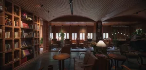 Warm and inviting restaurant interior with wooden floors and walls, featuring comfortable seating areas and potted plants