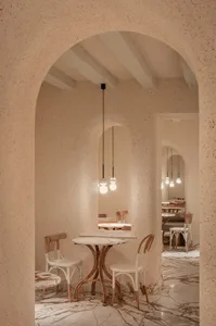 空蕩蕩的餐廳內部，白色餐桌、椅子與燈具營造寧靜而溫馨的氛圍