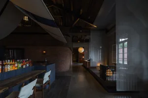 溫馨餐廳內部，木質地板、磚牆、椅子、餐桌與盆栽